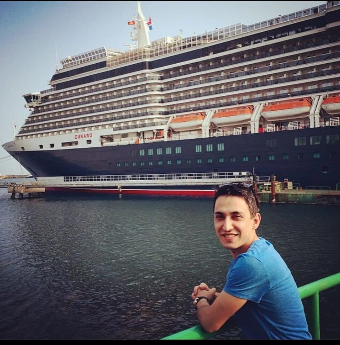 Alper Billik in front of a cruise ship in port